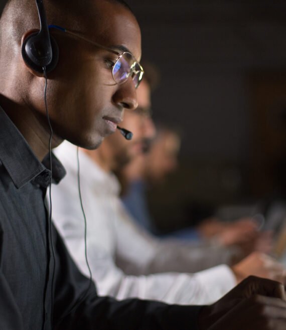 Focused call center operator typing on laptop