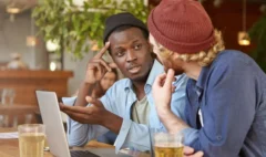 Two friends discussing over drinks.