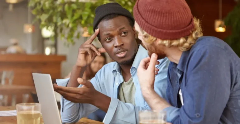 Two friends discussing over drinks.